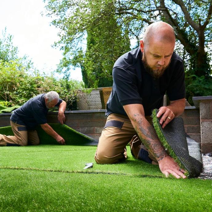 Two installers laying artificial turf