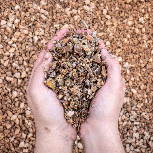 Hands cupping gravel for a gravel driveway installation