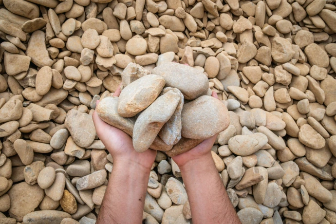 Hands displaying Alpine river pebbles (25-40mm)